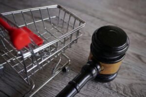 Closeup image of judge gavel and shopping trolley on table. Closeup image of judge gavel and shopping trolley on table.